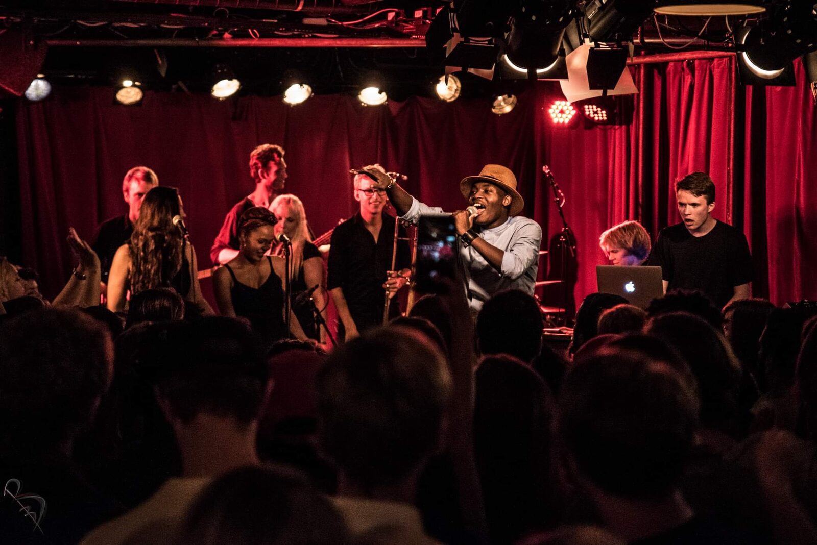 Elvic Kongolo and band on a red-lit stage in front of a crowd
